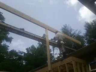 Carpenter setting a ridge beam over a new addition frame — Ice Dam Removal by Roofing Brothers in Rebersburg