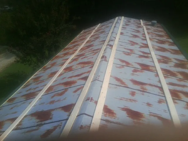 Rusted metal roof panels with new wood purlins before replacement — Storm Damage Roof Repair in Rebersburg by Roofing Brothers