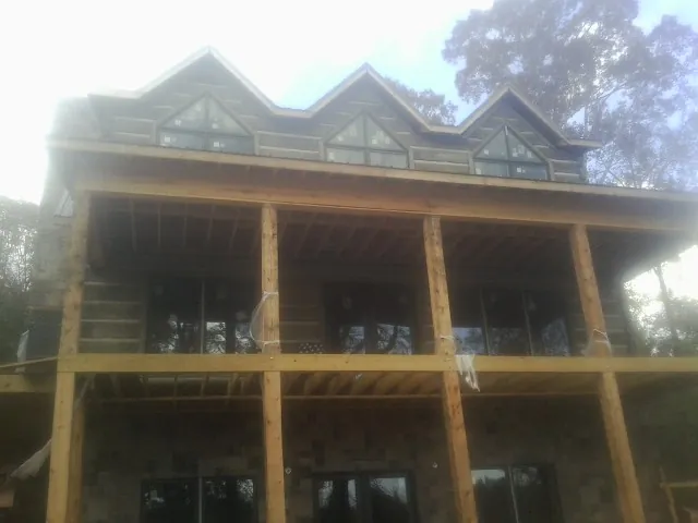 Dormers and porch framing on a large log home under construction — Roof Coating work by our crew in Rebersburg